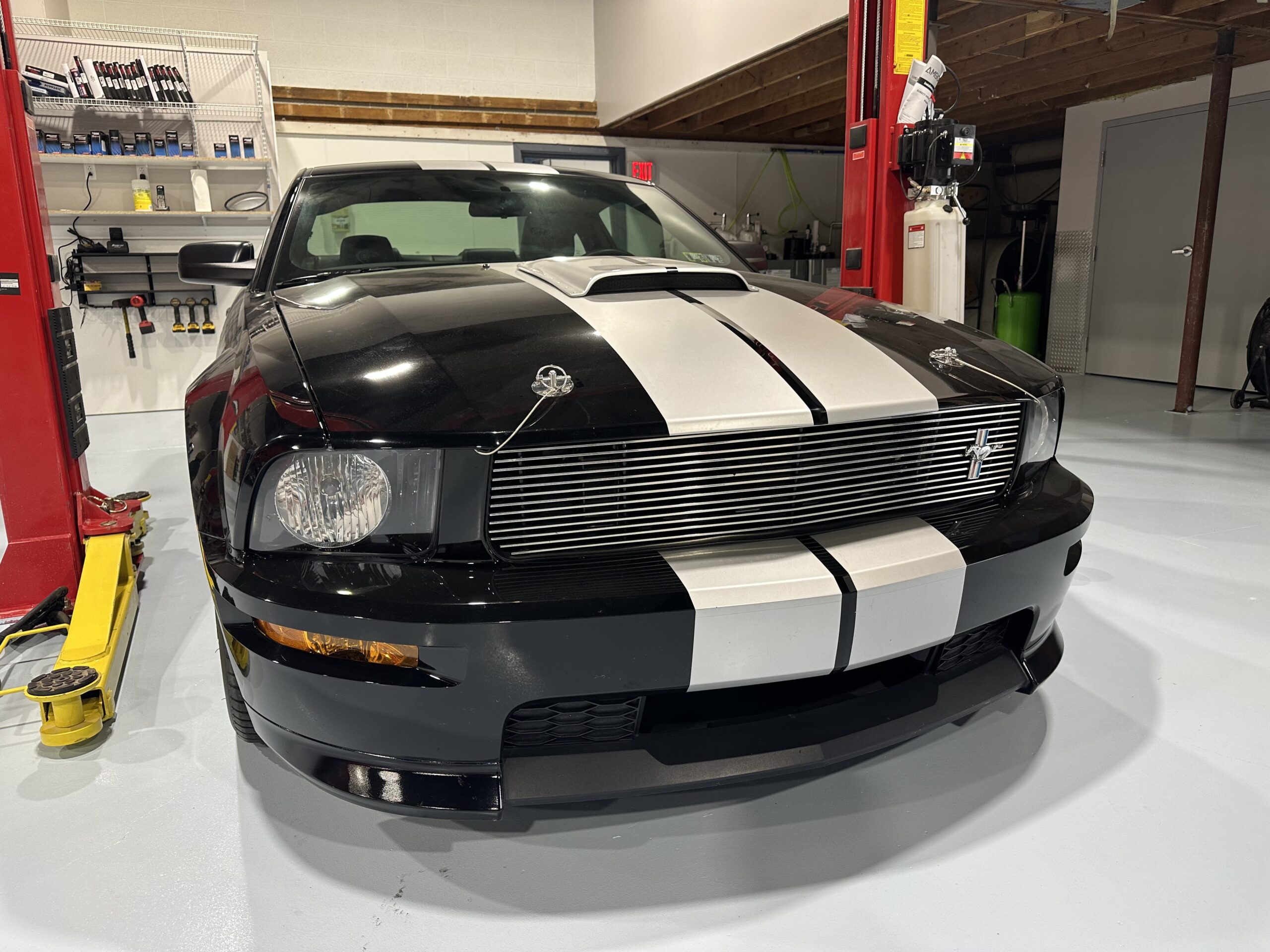 black Shelby Mustang parked in bay inside of shop